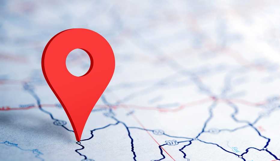 close up of a red map pin icon on a road map